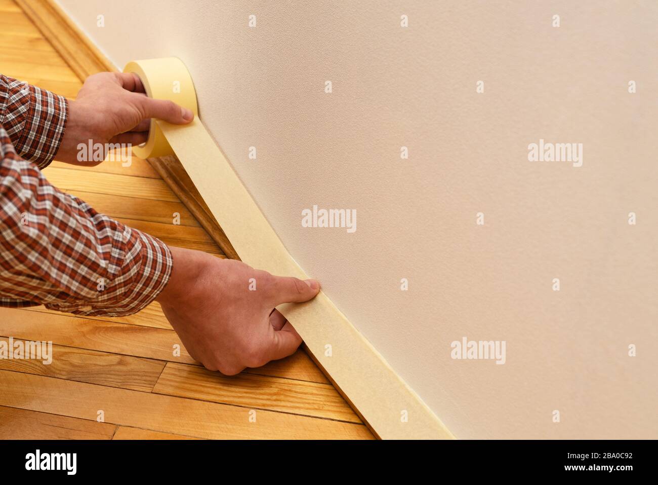 Interior painting apply painter's tape to baseboard Stock Photo Alamy