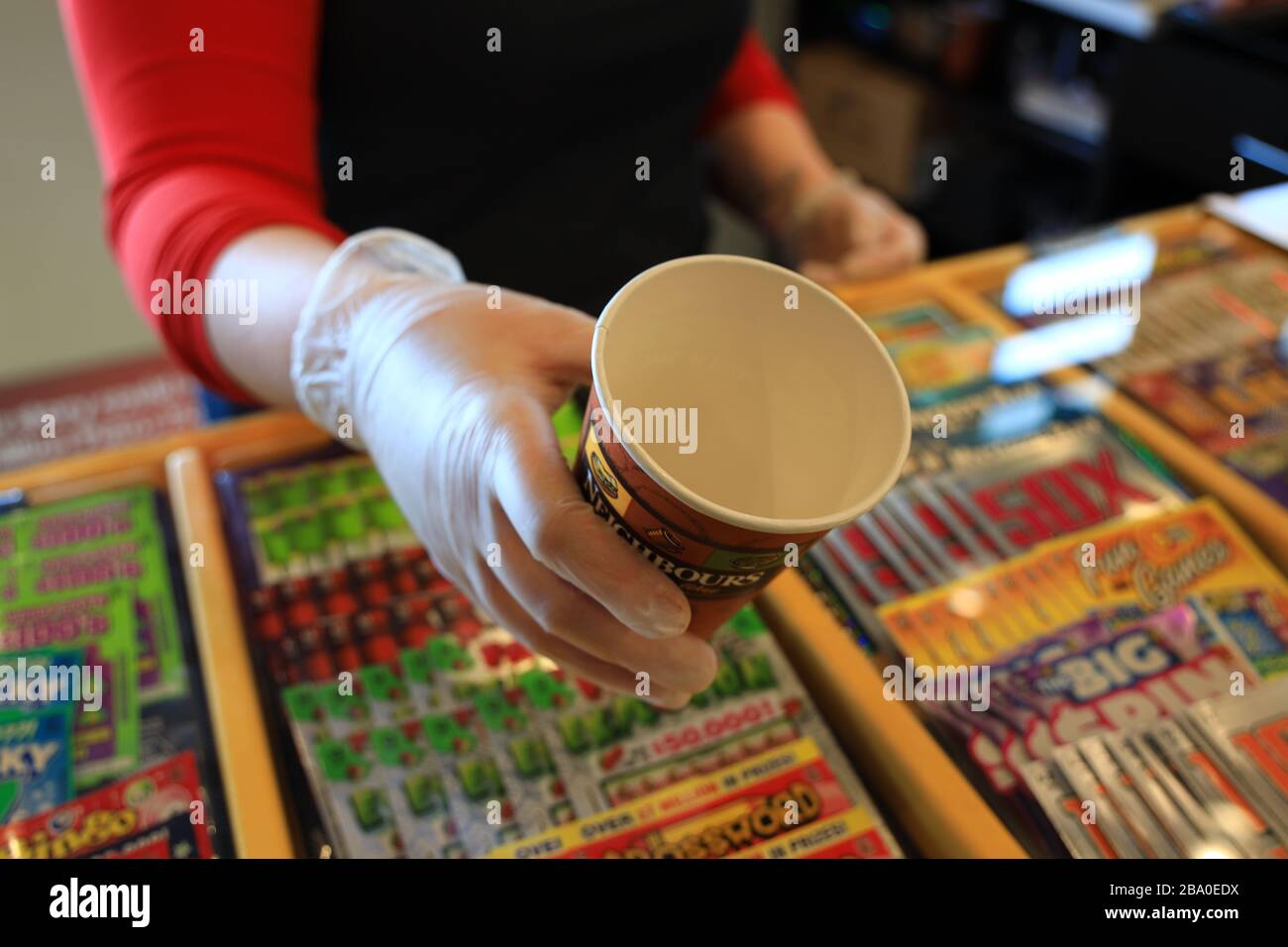 Gloved hands holding a coffee cup Stock Photo - Alamy