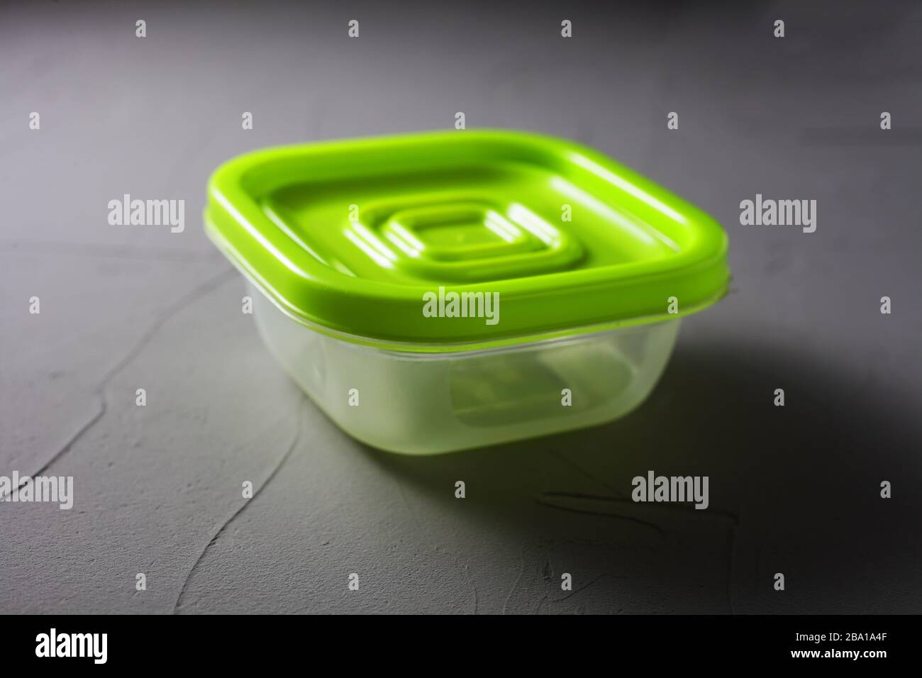 Plastic green food container on bitmap background soft focus Stock