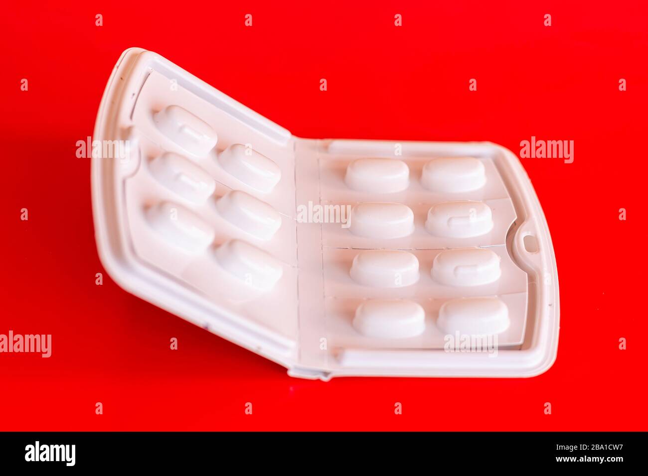 White booklet of painkillers pills on red background.Blister of generic paracetamol tablets.No people and copy space.Popular Over-counter medication. Stock Photo