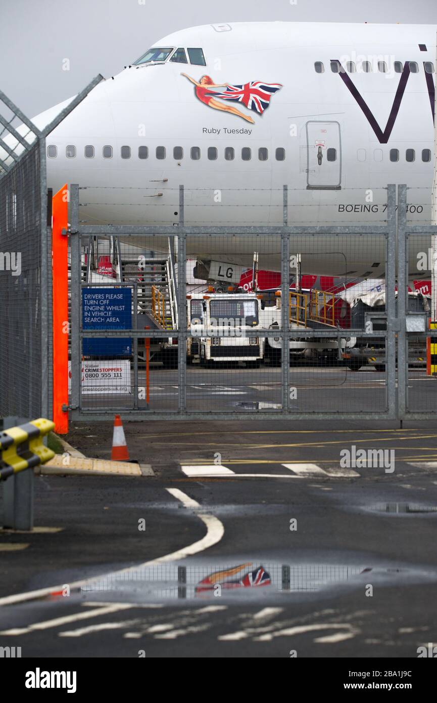 Glasgow, UK. 25th Mar, 2020. Pictured: Virgin Atlantic aircraft (Boeing 747-400 series - named Ruby Tuesday, registered G-VXLG) and an Airbus A330-200 - named Honkytonk Woman, registered G-VMIK) stand grounded on the tarmac by the Logan Air hanger. Credit: Colin Fisher/Alamy Live News Stock Photo