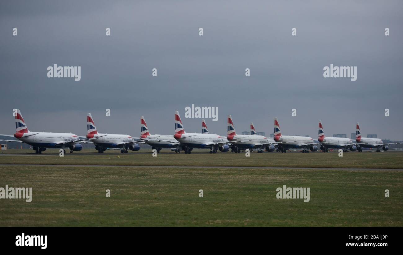 Glasgow, UK. 25th Mar, 2020. Pictured: British Airways Airbus Aircraft stand grounded on the tarmac at Glasgow Airport. The group of Airbus Aircraft comprise of Airbus A321, A320 and one A319 aircraft. Credit: Colin Fisher/Alamy Live News Stock Photo