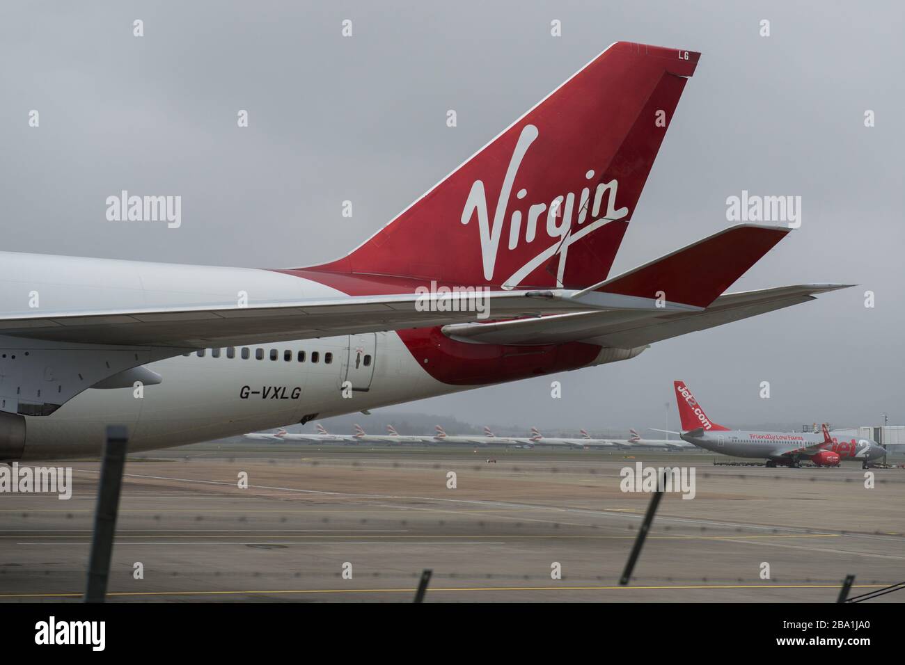 Glasgow, UK. 25th Mar, 2020. Pictured: Virgin Atlantic aircraft (Boeing 747-400 series - named Ruby Tuesday, registered G-VXLG) and an Airbus A330-200 - named Honkytonk Woman, registered G-VMIK) stand grounded on the tarmac by the Logan Air hanger. Credit: Colin Fisher/Alamy Live News Stock Photo