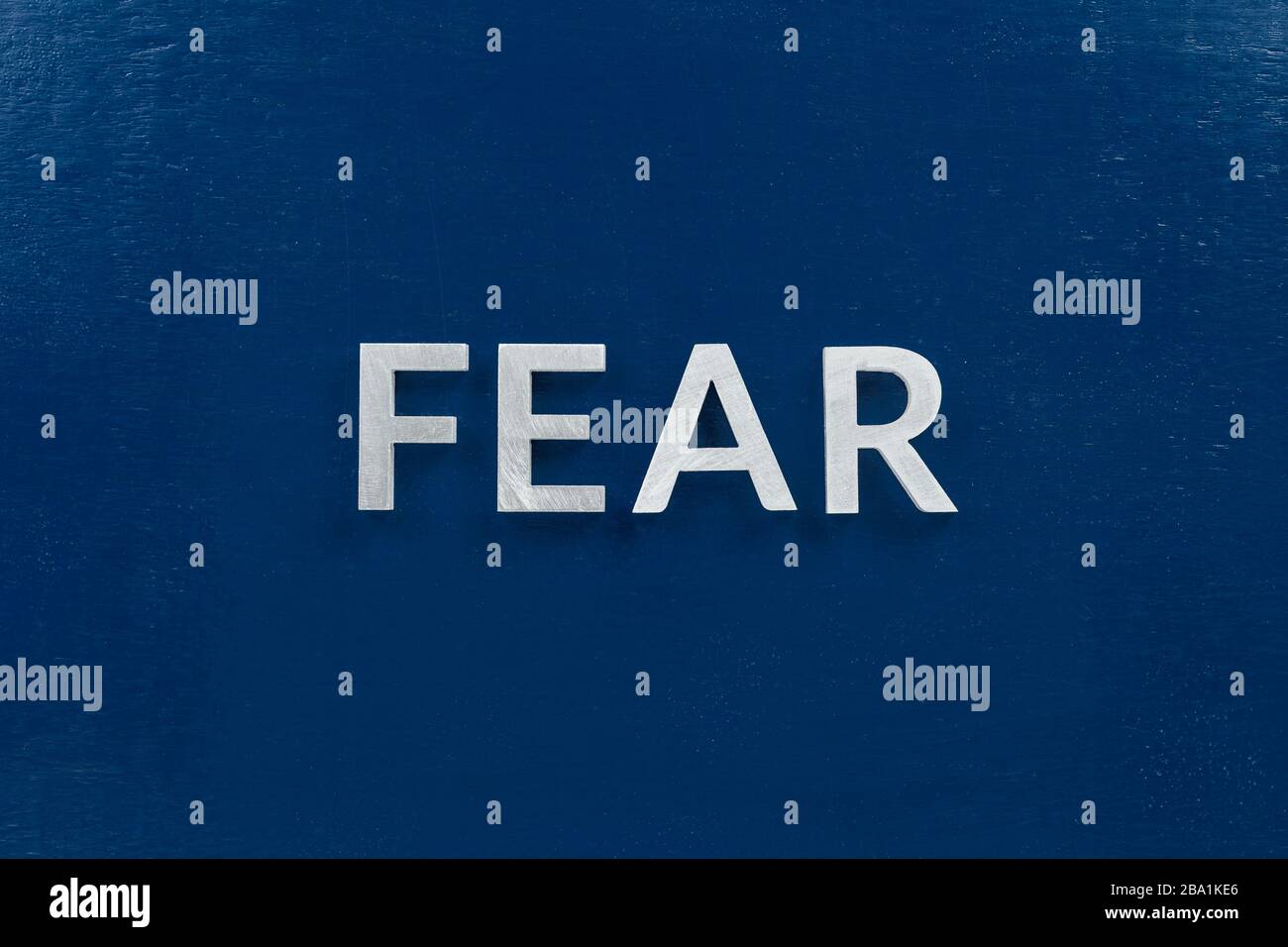 the word fear laid with silver letters on flat blue surface Stock Photo