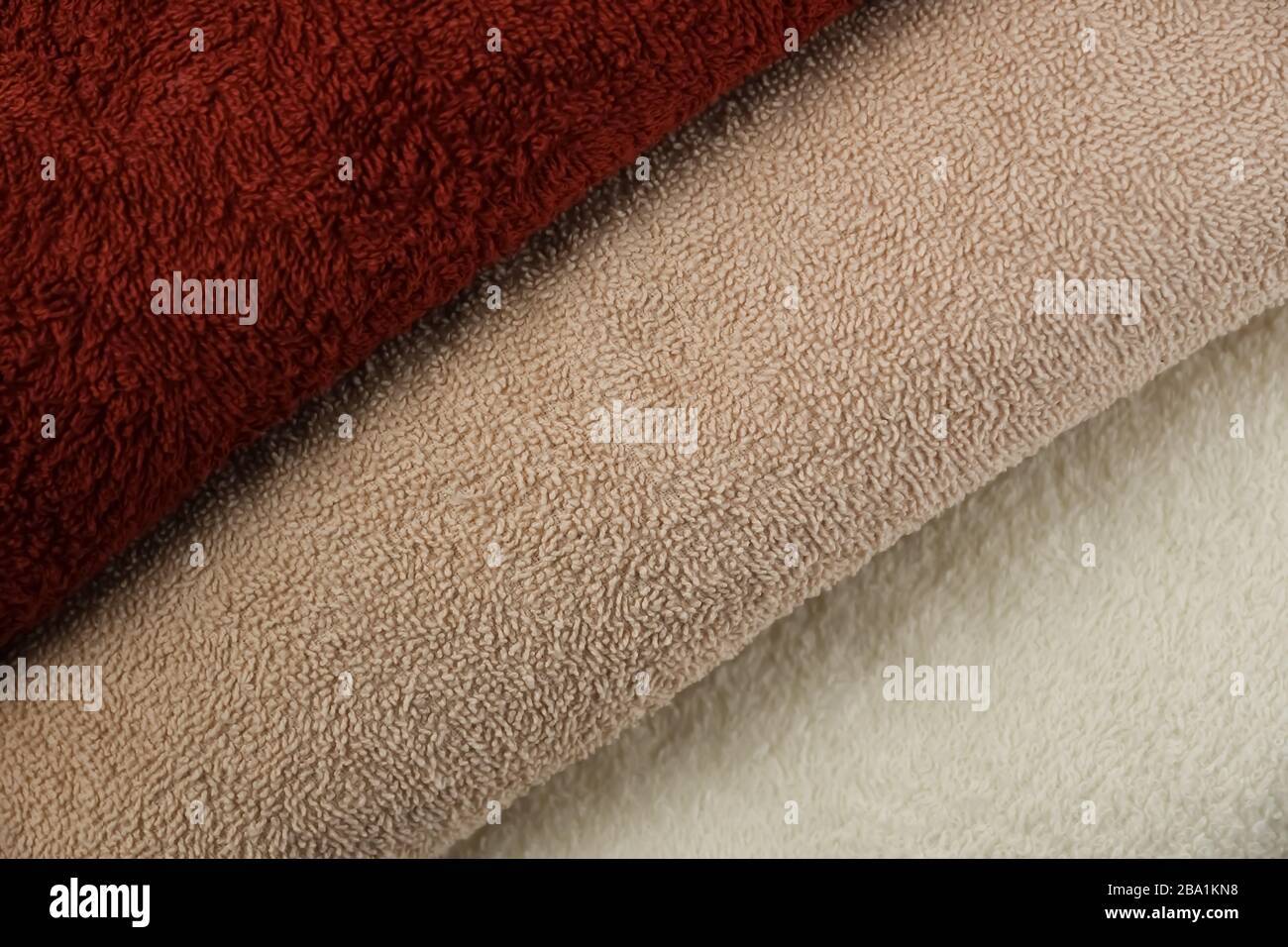 Soft texture of folded cherry and beige terry towels. Stock Photo