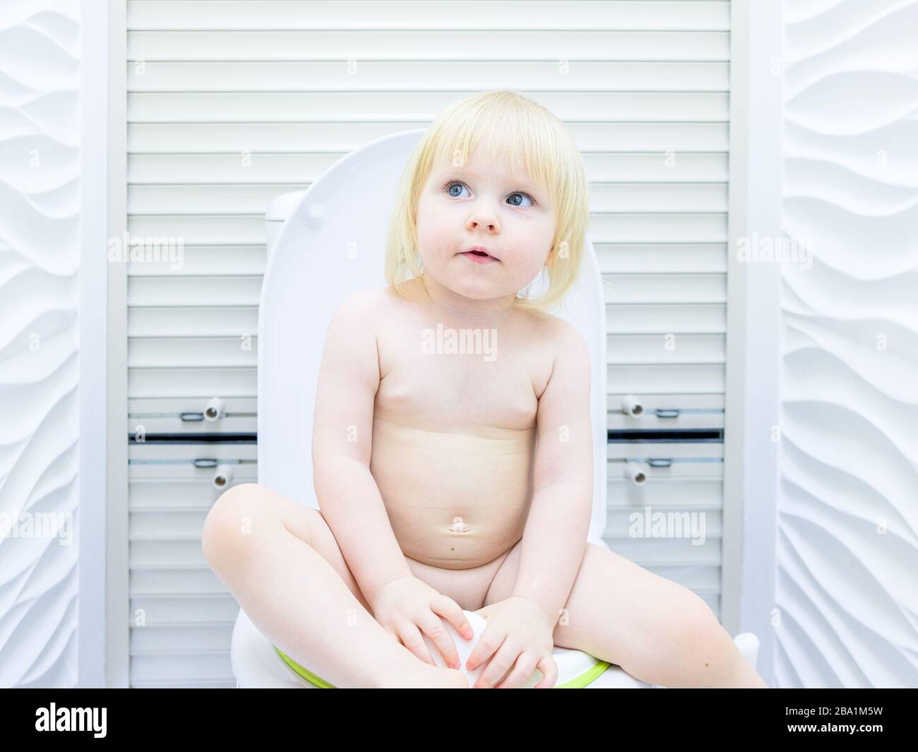 Little girl on toilet A little blonde girl with a mischievous look sits on the toilet in a  brightly lit toilet room. A happy child pisses and has fun Stock Photo -  Alamy