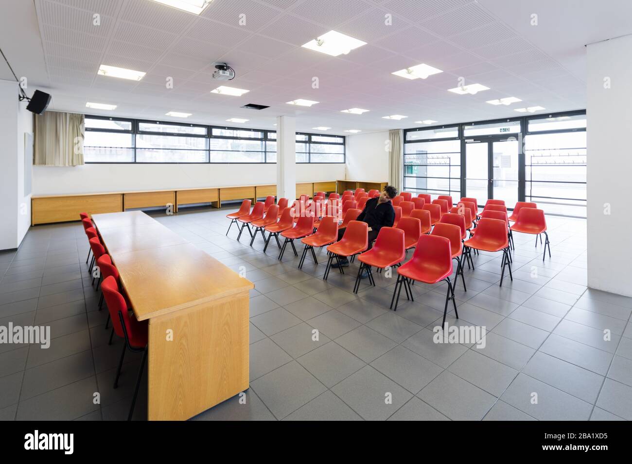 Lonely man in the conference room with red chairs Stock Photo