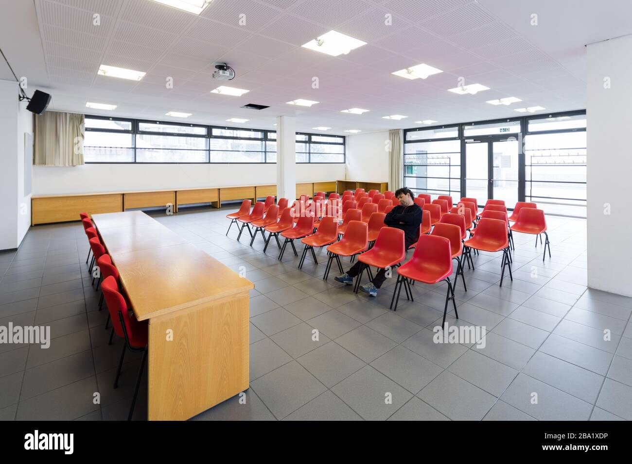 Lonely man in the conference room with red chairs Stock Photo