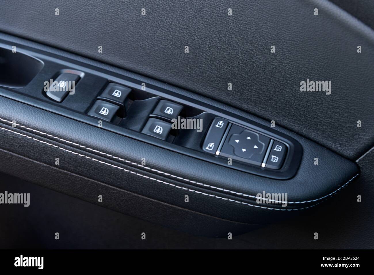 Image in closeup of a door control panel in a modern car. Arm rest with window control panel