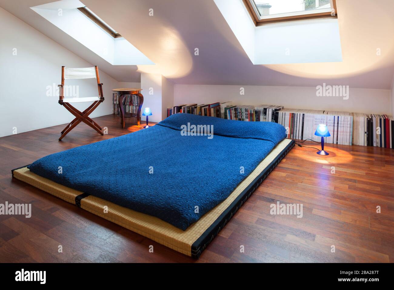 Interior, nice loft, bed with bedspread blue Stock Photo