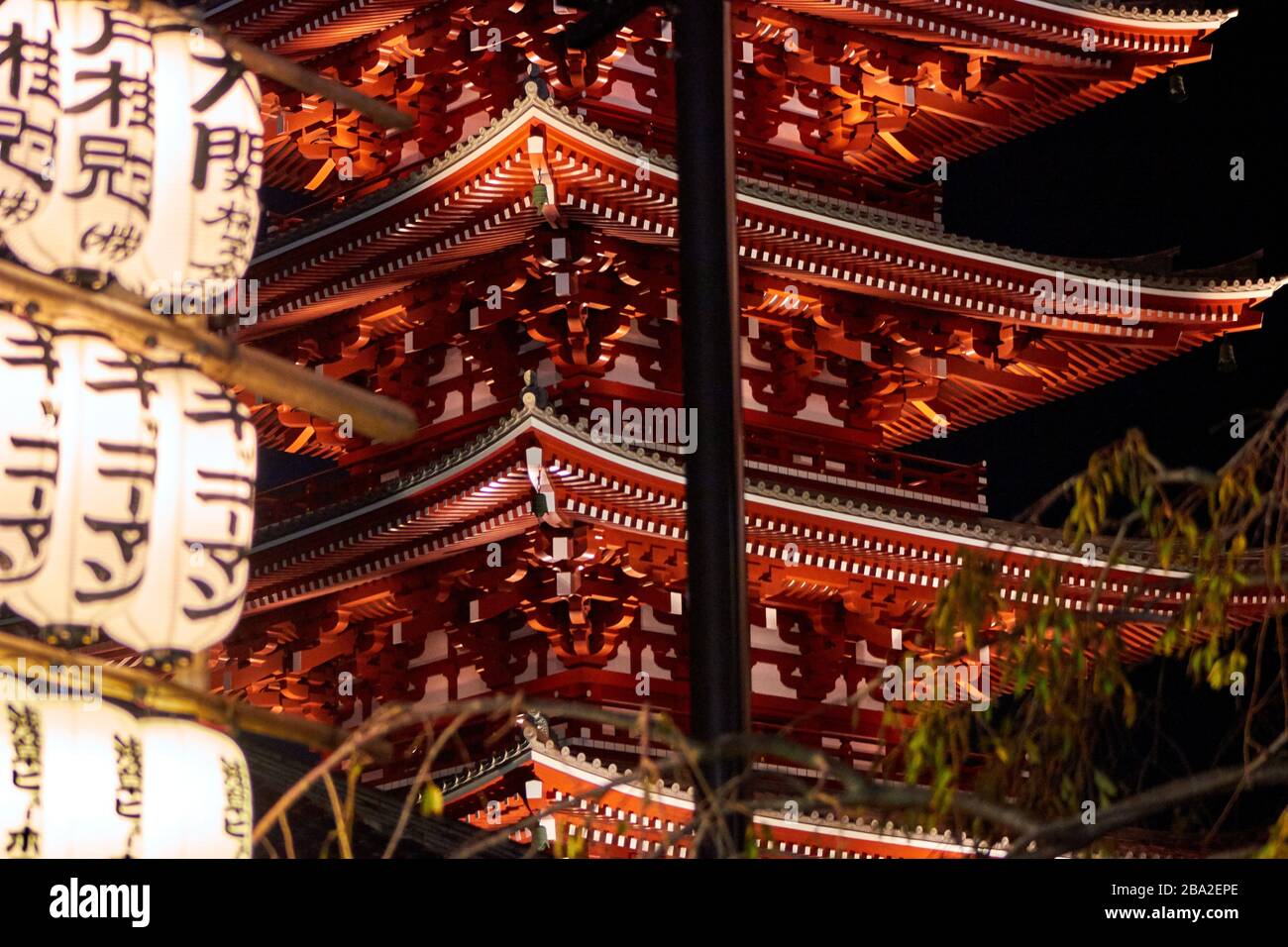Lanterns with Japanese kanji and pagoda in the background at night