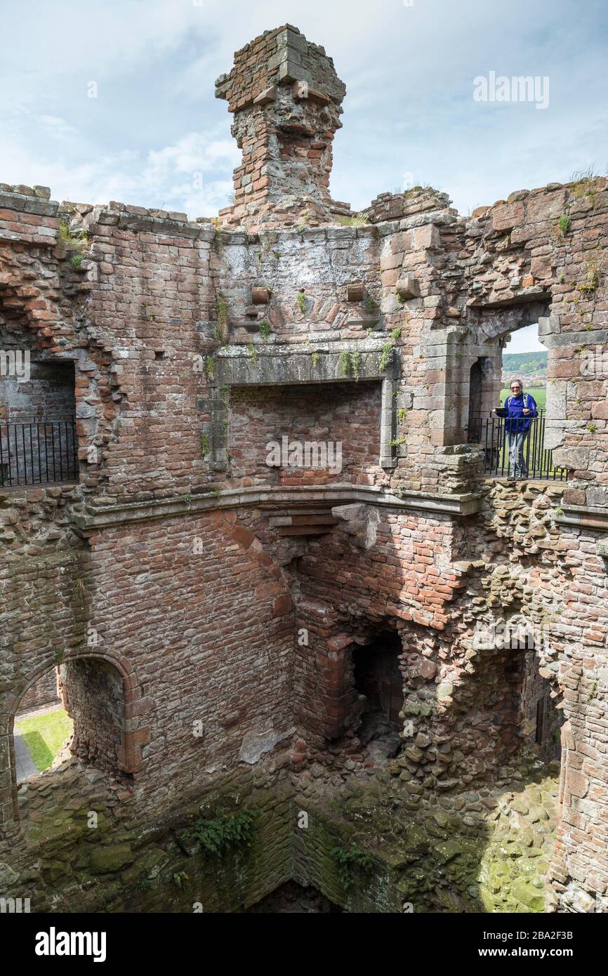 Woman looking through window in Brougham Castle ruin, Cumbria, England, UK Stock Photo