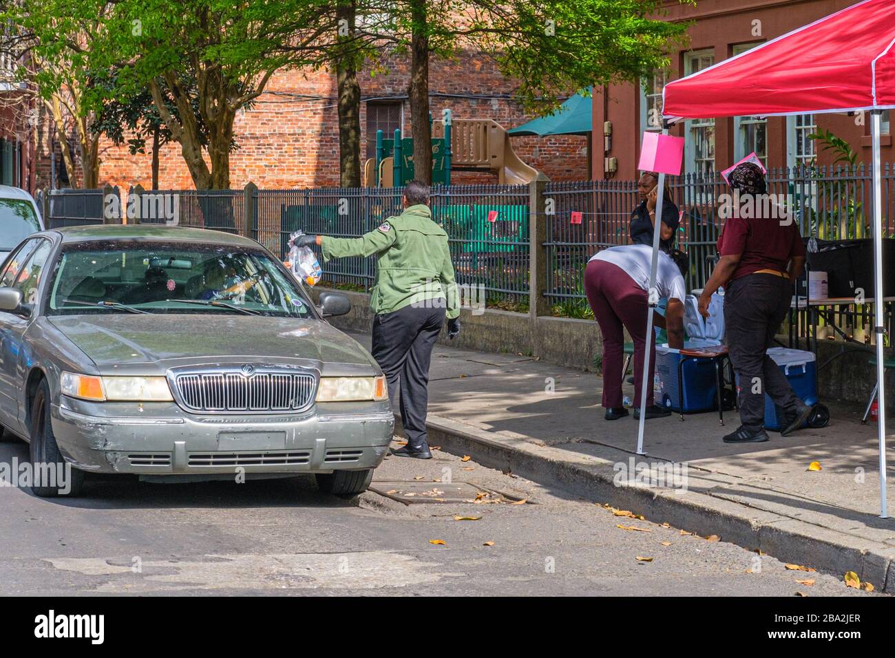 New Orleans, LA/USA - 3/21/2020: Volunteers Distributing Free Meals to Parents of School Children Forced to Stay Home Due to Covid-19 Pandemic Stock Photo