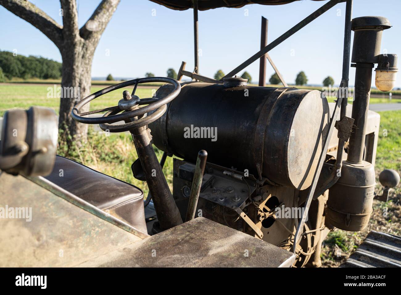 Old and ancient famo catapillar working with a plow in the fields, showing how farming was done many years ago. Stock Photo