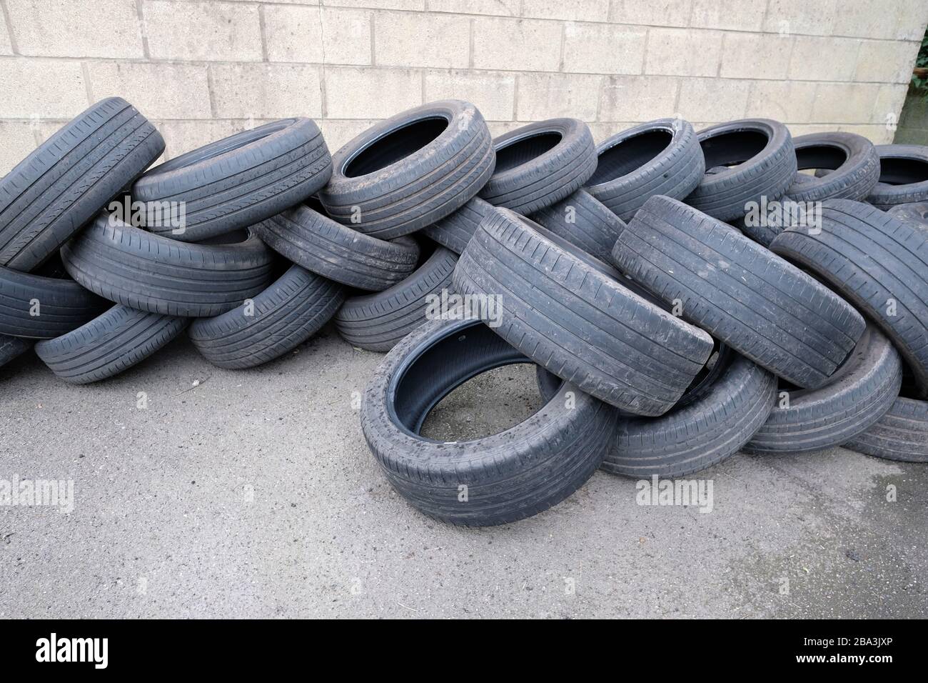 February 2020 - Old tyres stacked ready for recycling outside a garage in the Somerset village of Cheddar. Stock Photo
