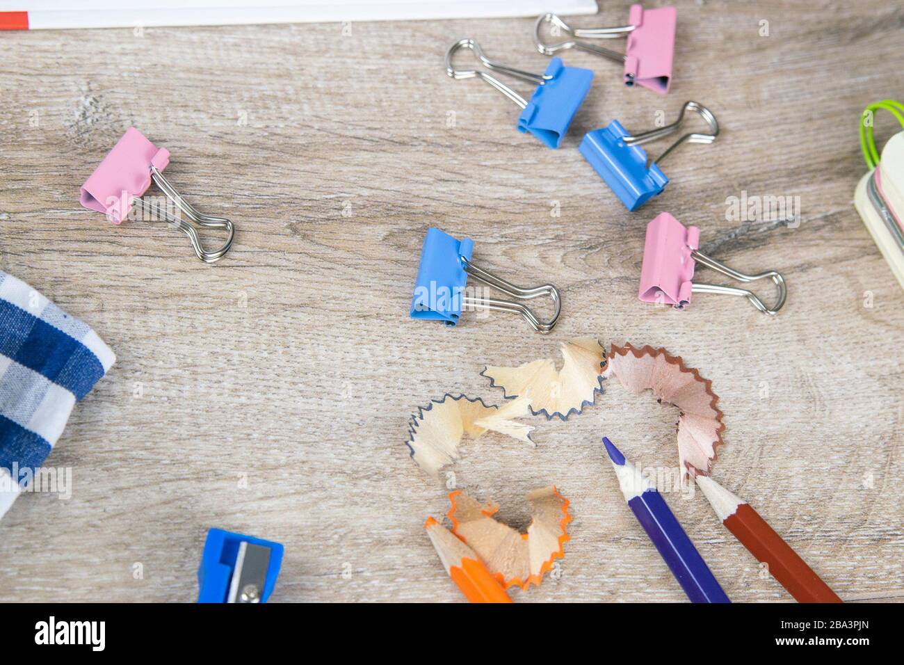 Pencil sharpening shavings and a few pencils on a wooden table Stock Photo