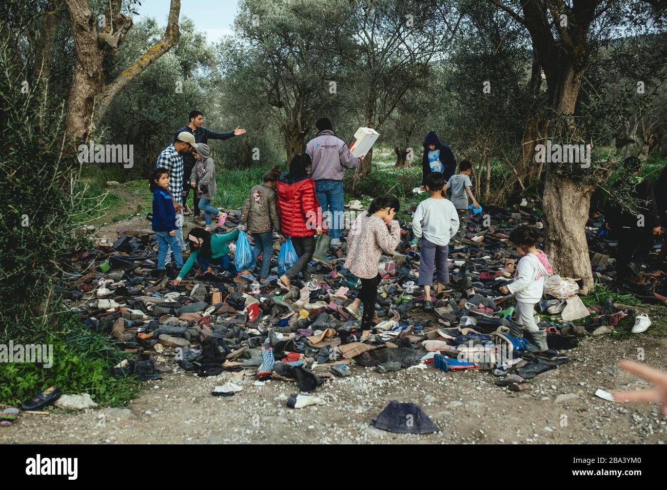 Refugees look for shoes from a pile of donations, Refugee camp in Moria, Lesbos, Greece Stock Photo