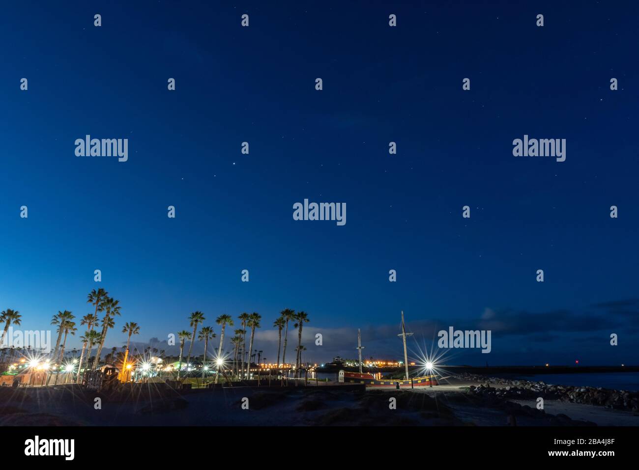Star constellations still visible in the dawn sky as morning breaks over this California beach park. Stock Photo