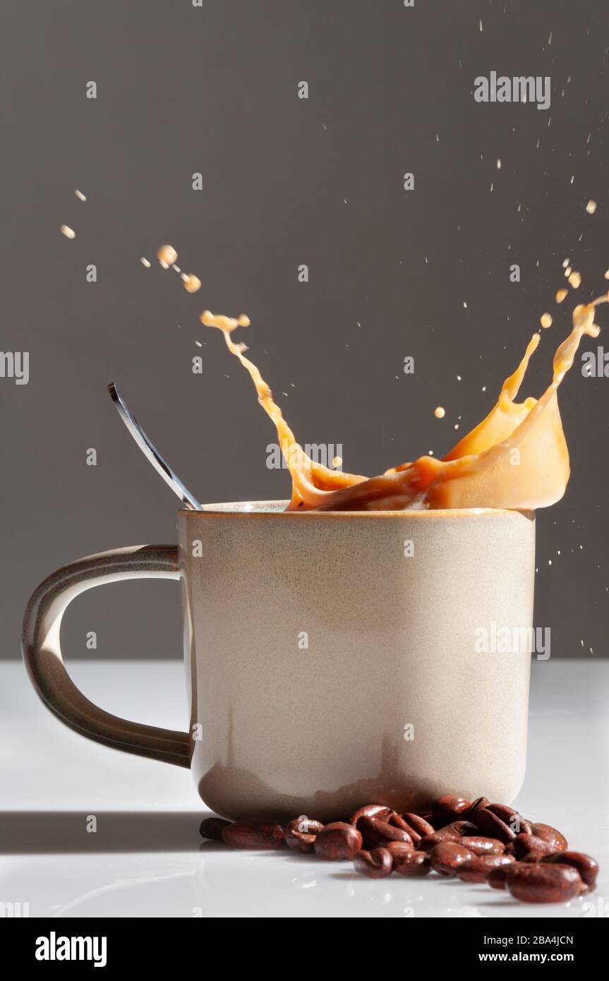 https://c8.alamy.com/comp/2BA4JCN/coffee-mug-with-coffee-beans-and-coffee-splash-2BA4JCN.jpg