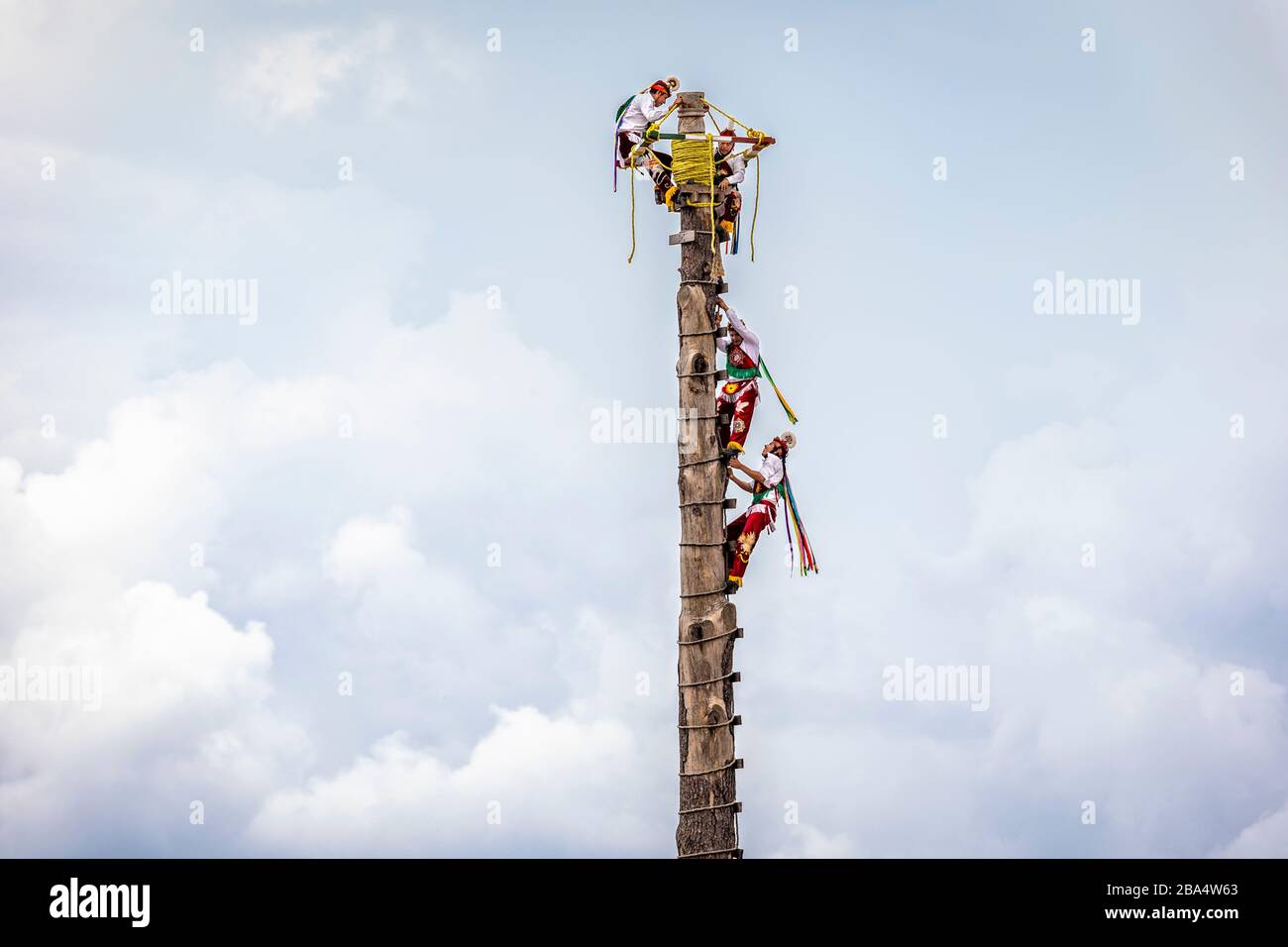 Voladores or fliers climb up into the clouds before descending around the post to the ground in Cuetzalan, Puebla, Mexico. Stock Photo