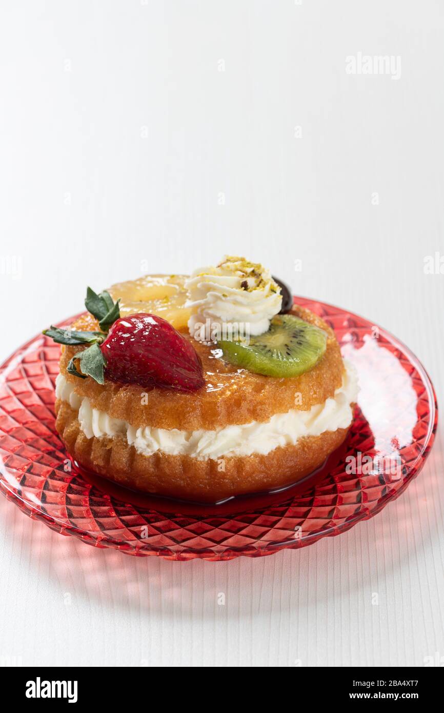 Italian sweet of Naples with rum syrup with fresh strawberries, kiwis, pineapple and whipped cream Stock Photo