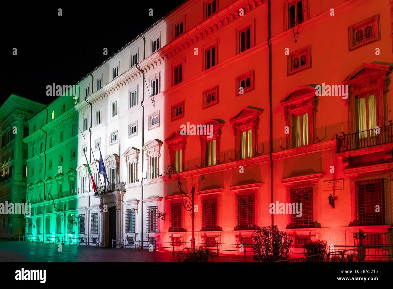 Rome, Italy - March 24, 2020: Palazzo Chigi, seat of the Italian government, facade of the building illuminated with the colors of the Italian flag. Coronavirus emergency Italy. Stock Photo