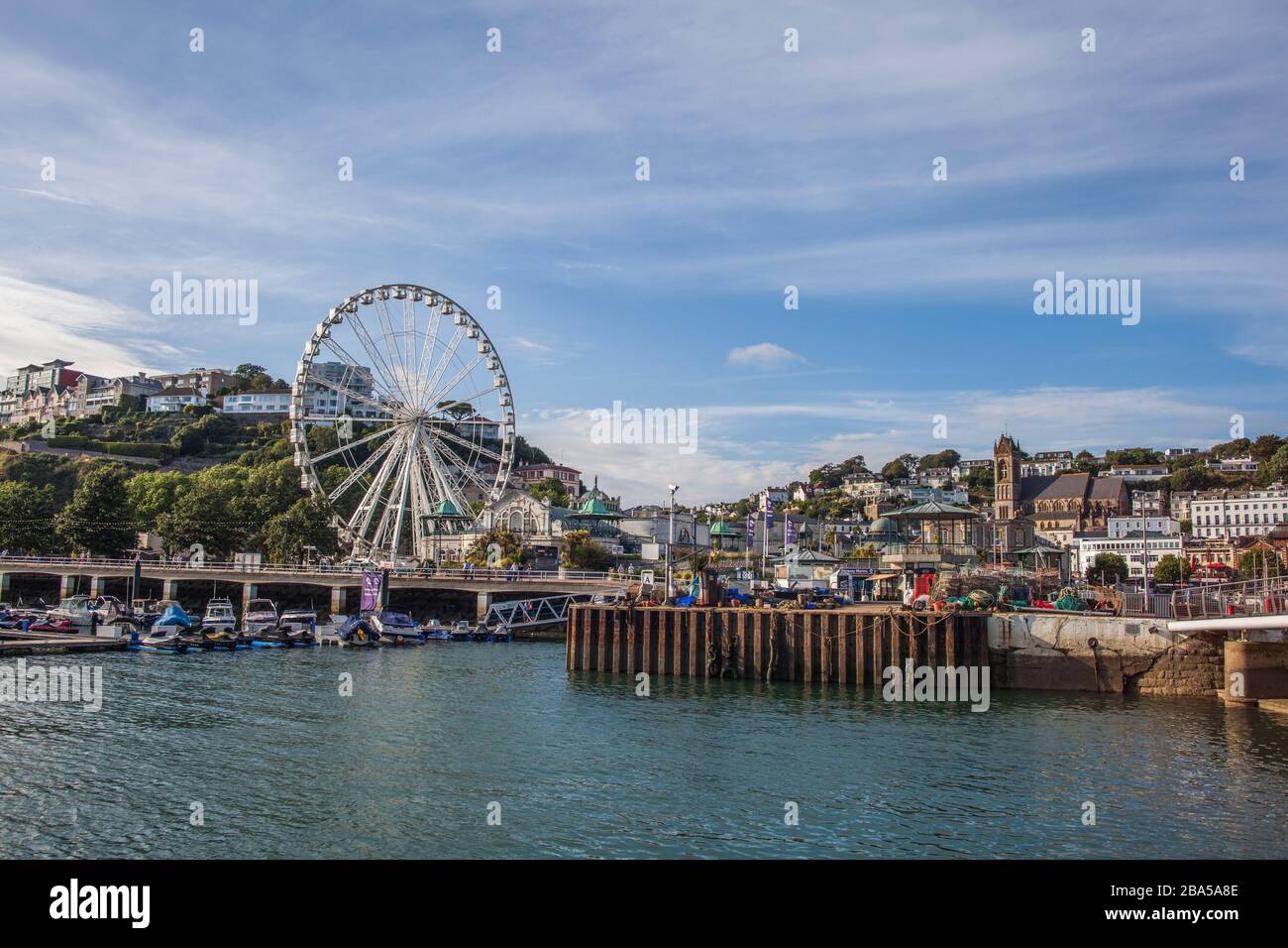 Ferris wheel on a harbour. Summer, spring. Scenes with bridge or pier with water, sea, beach, harbour. Boats, townscape or seascape Stock Photo