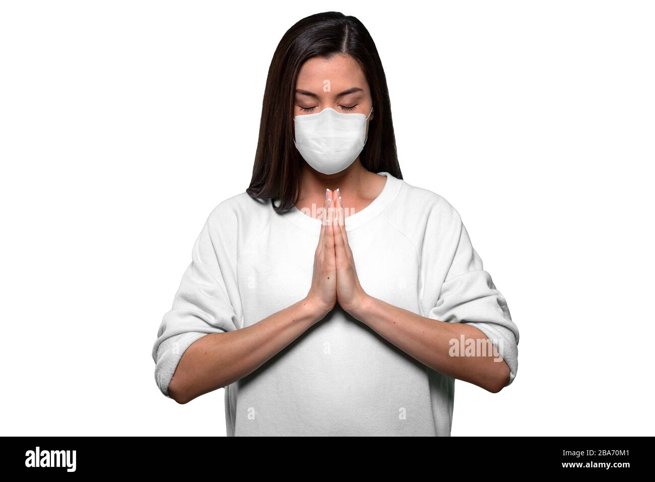 Asian american woman staying calm and finding peace through prayer and meditation during pandemic crisis Stock Photo
