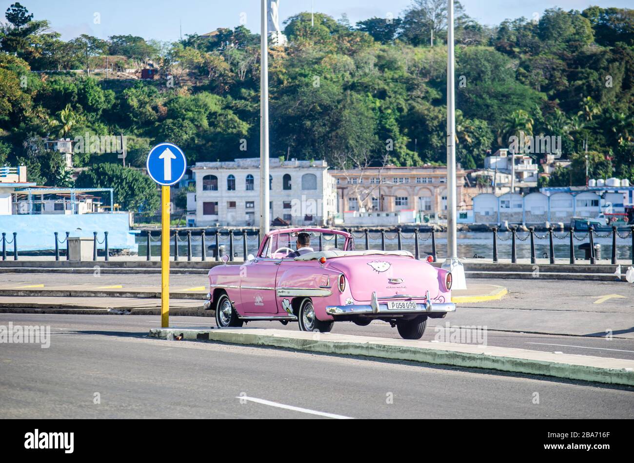 A pink classic car is transiting the Malecon Stock Photo