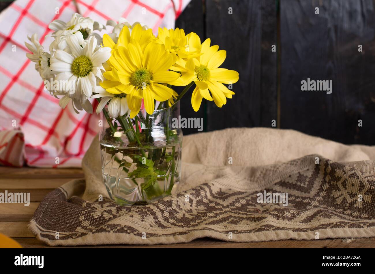 A glass vase with yellow and white flowers Stock Photo Alamy