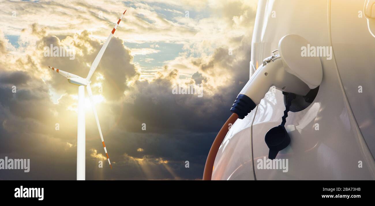 Electric car with charging plug on a background of wind turbines Stock Photo
