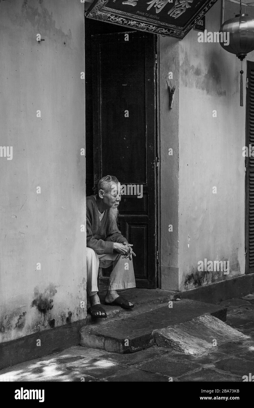 Old Vietnamese man in doorway Stock Photo