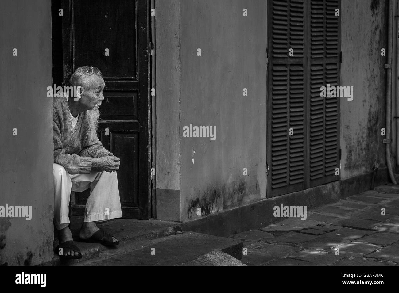 Old Vietnamese man in doorway Stock Photo