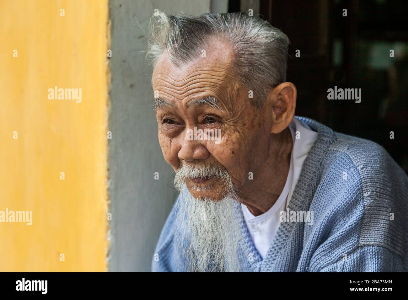 Old Vietnamese man in doorway Stock Photo
