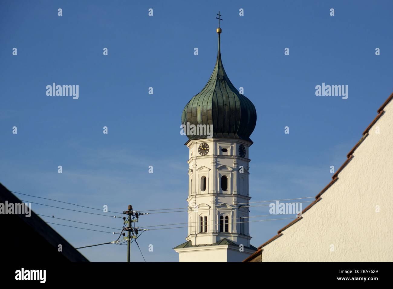 rural onion dome of a church with church clock and in the foreground