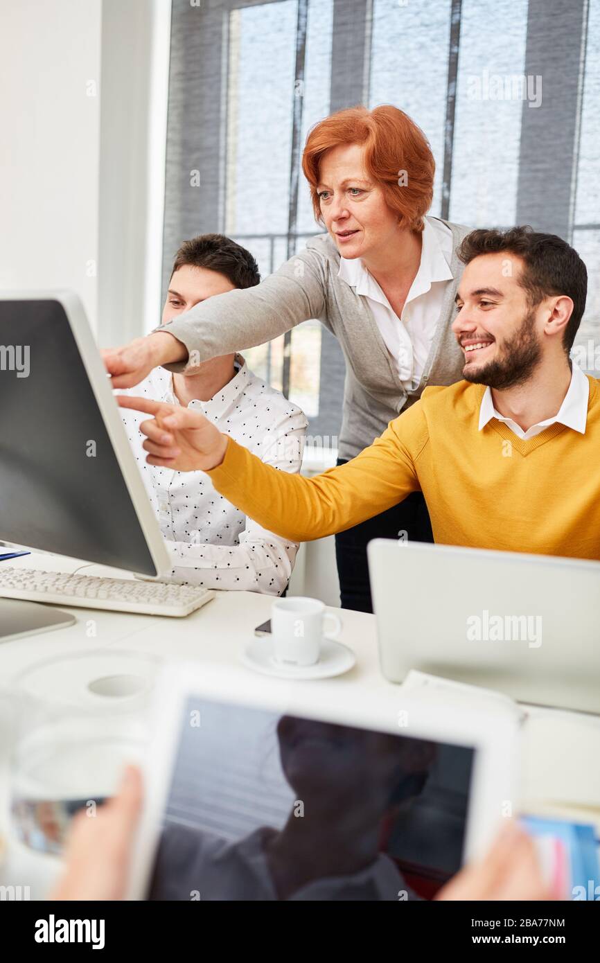 Business group looks at monitor from computer while e-learning on the Internet Stock Photo