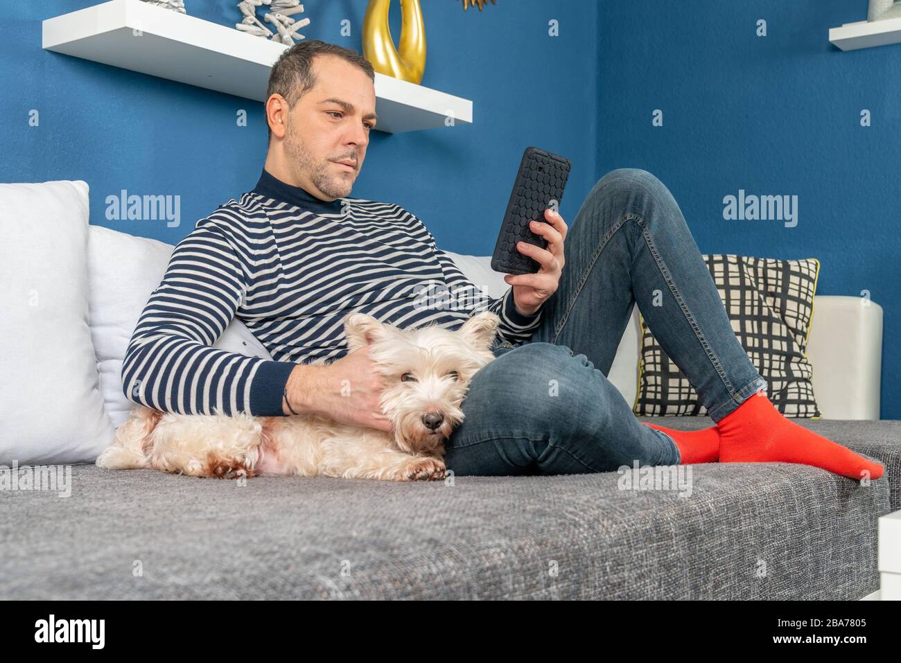 a man relaxes with his dog on the couch Stock Photo