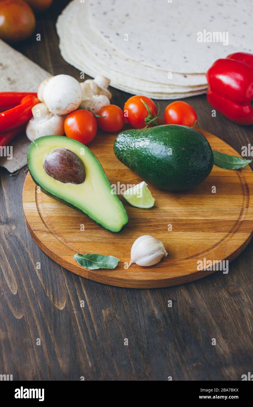Avocado fruit on wooden board with other vegetables Stock Photo - Alamy