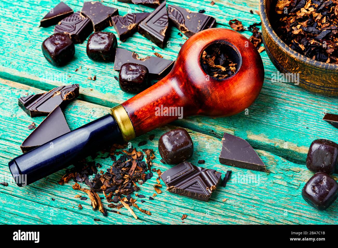 Chocolate flavored tobacco for smoking pipes.Tobacco pipe filled with  tobacco.Smoking pipe on wooden table Stock Photo