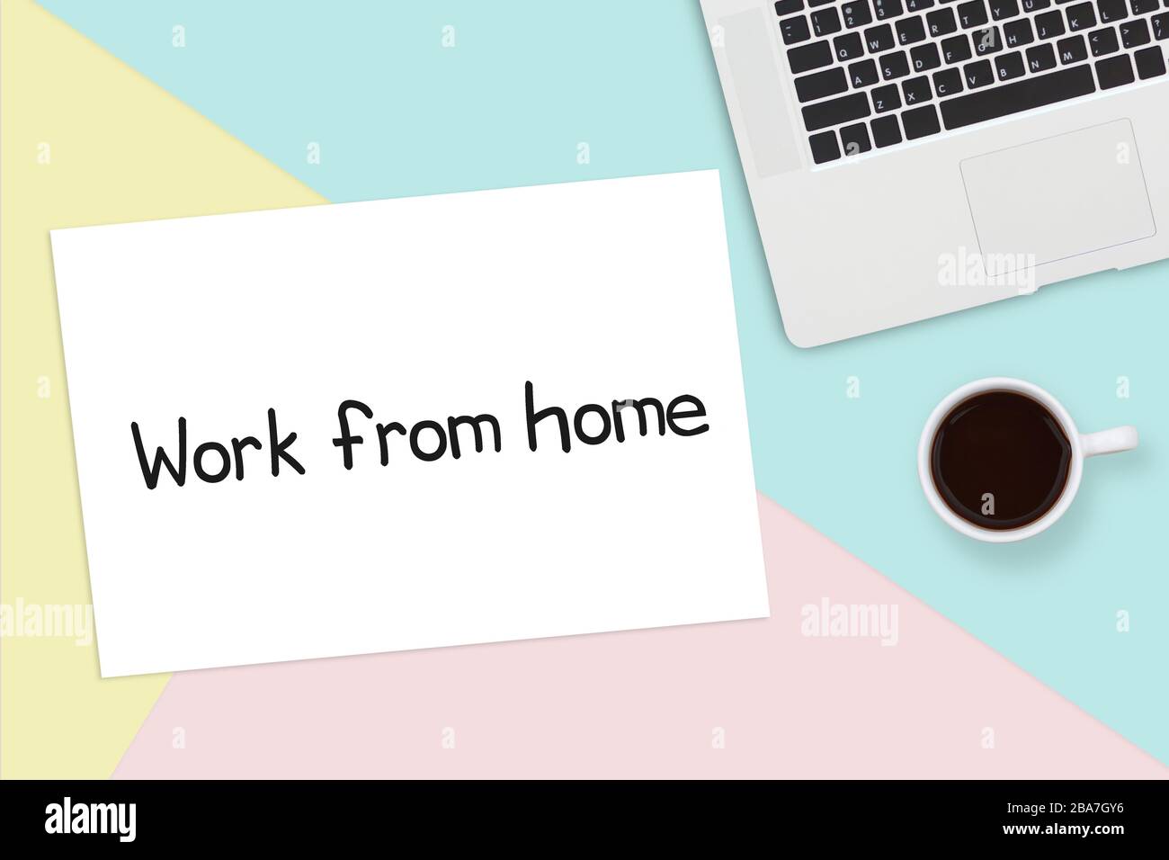 work from home concept. notebook laptop computer and a cup of coffee on office desk table, paper with text work from home on copy space Stock Photo