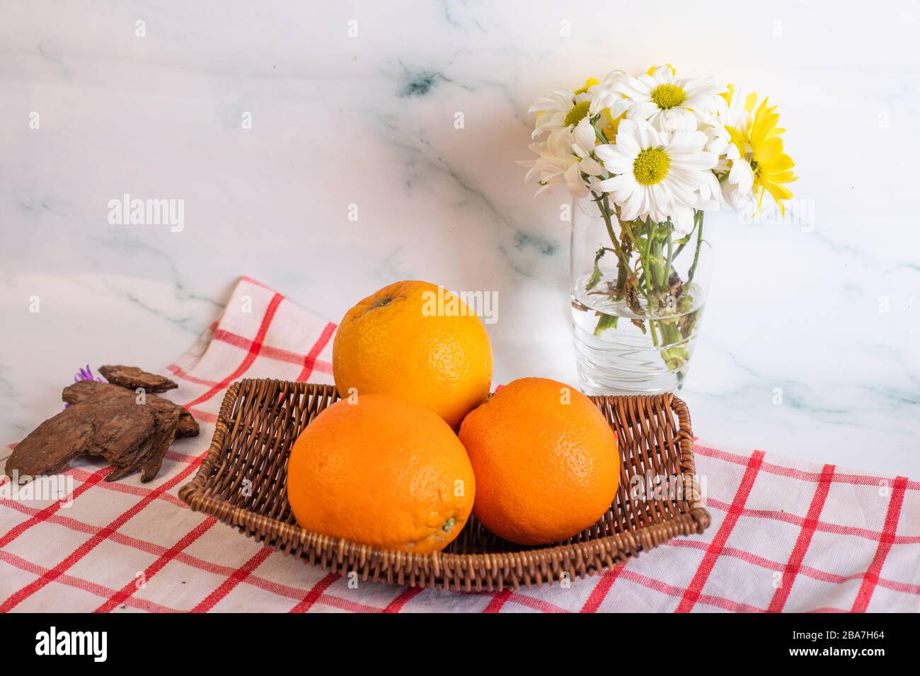 Oranges in a platter on the checked towel Stock Photo