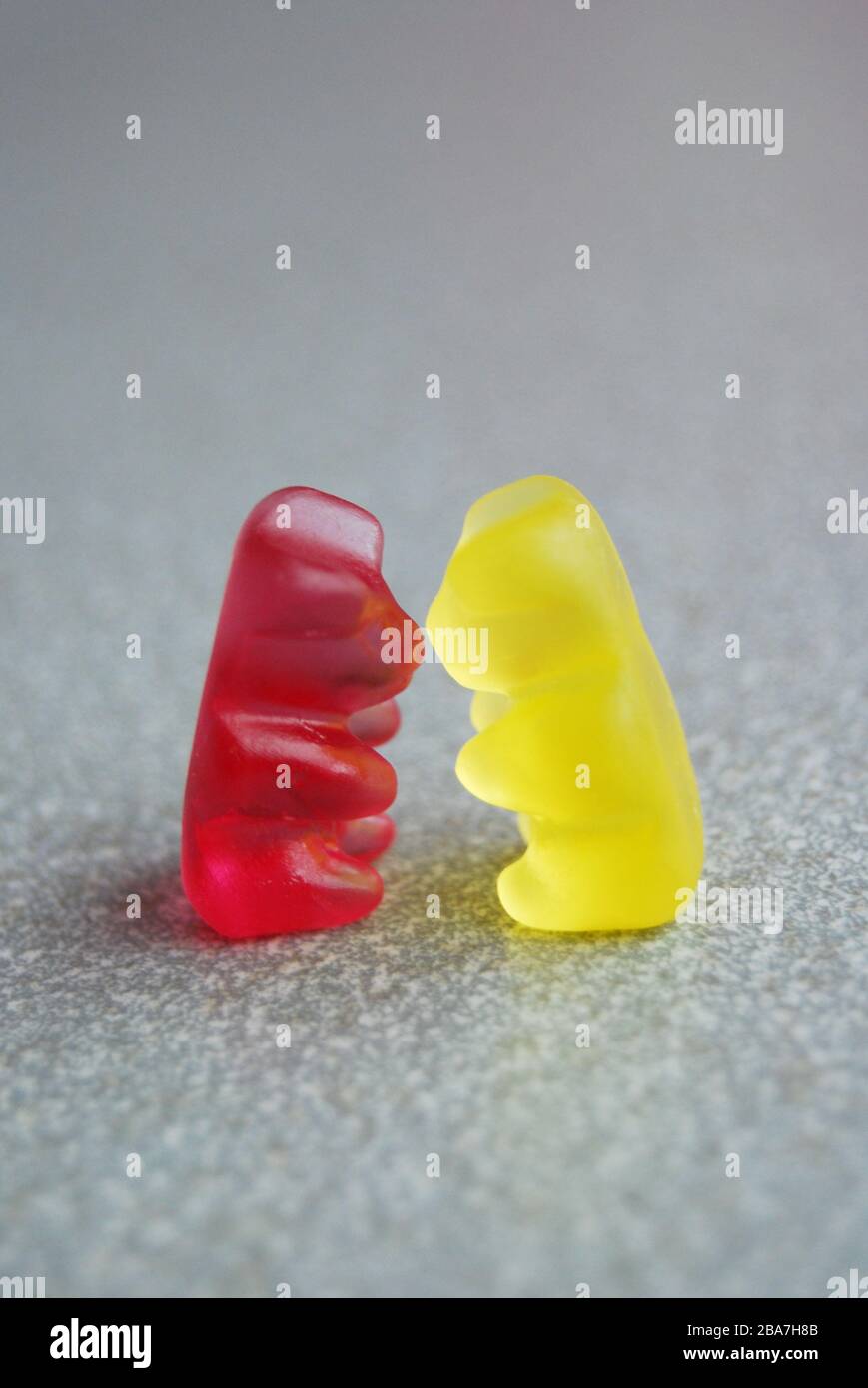 Kissing gummy bears, yellow and red, on a grey background. Funny Love  Concept Stock Photo - Alamy