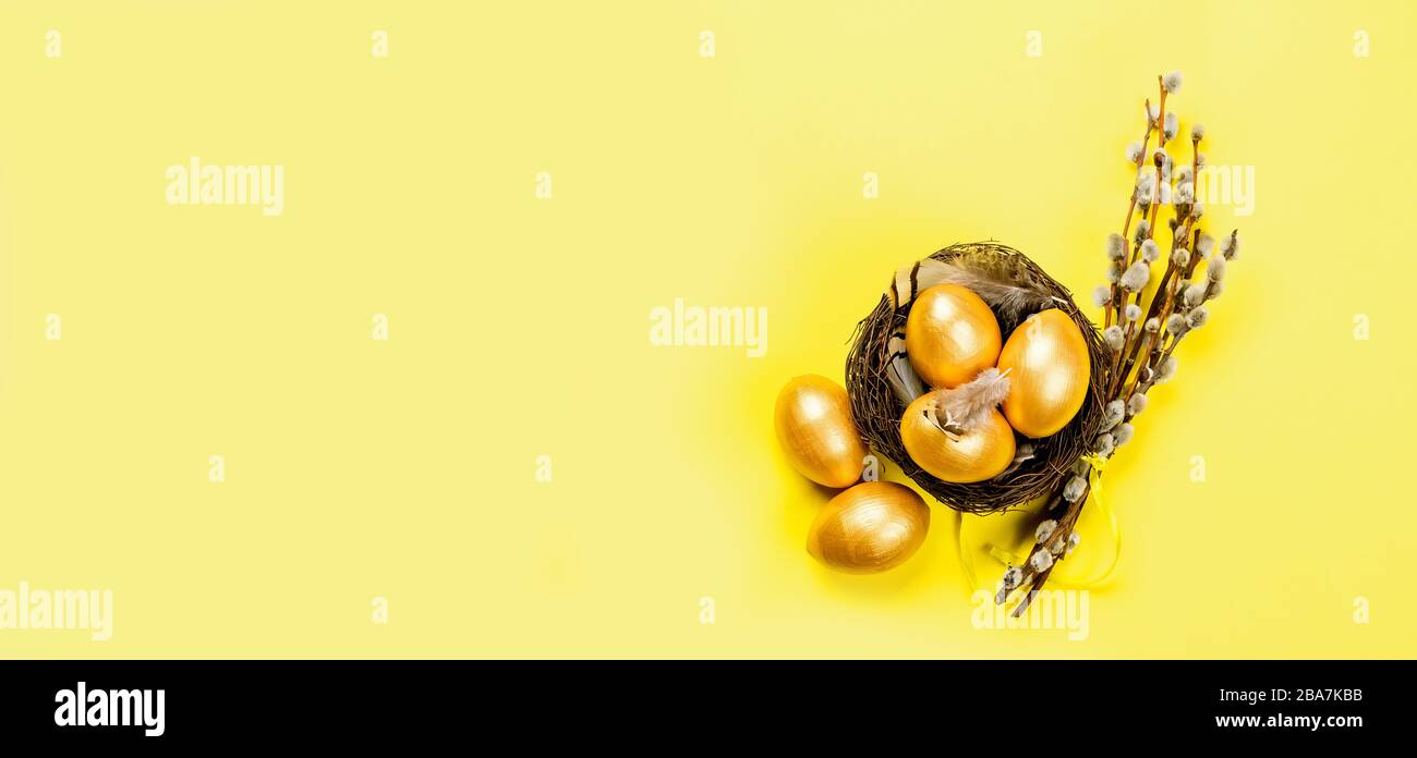 nest with gold decorative eggs and feathers in the nest on a gold ...