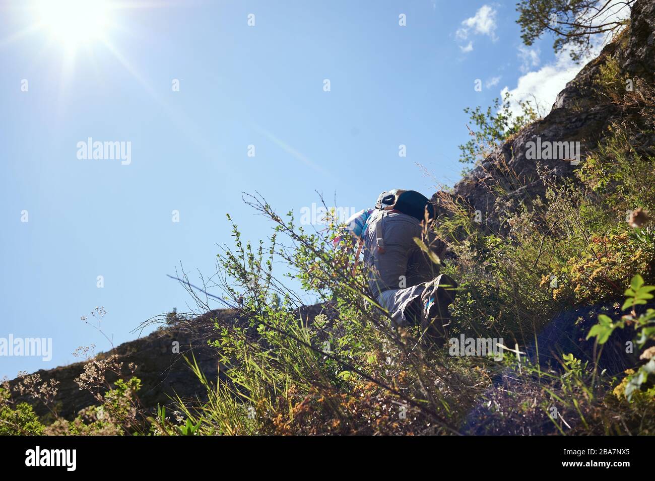 Girl rock climber climbs on the rock with the lower insurance men