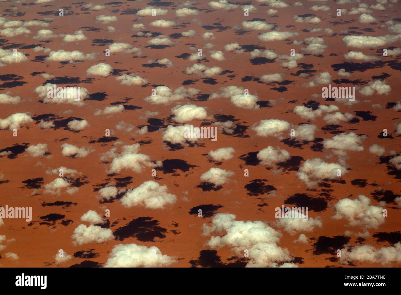 Aerial photograph of small clouds over desert sands in Saudi Arabia, casting small shadows. Stock Photo