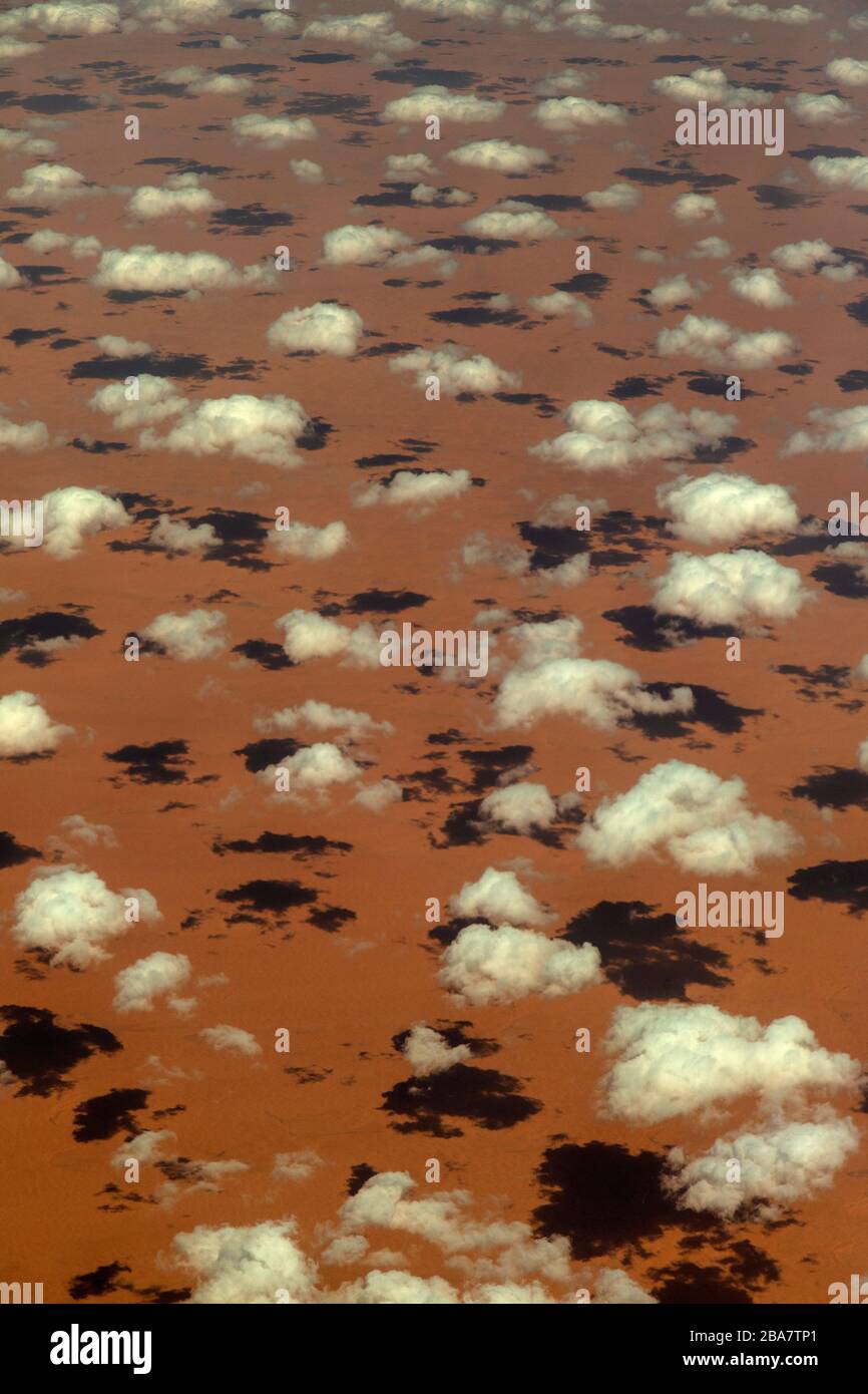 Aerial photograph of small clouds over desert sands in Saudi Arabia, casting small shadows. Stock Photo