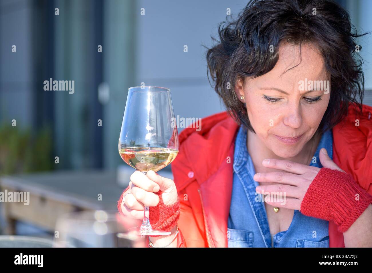 Woman coughing holding her hand to her chest with respiratory distress as she enjoys a glass of