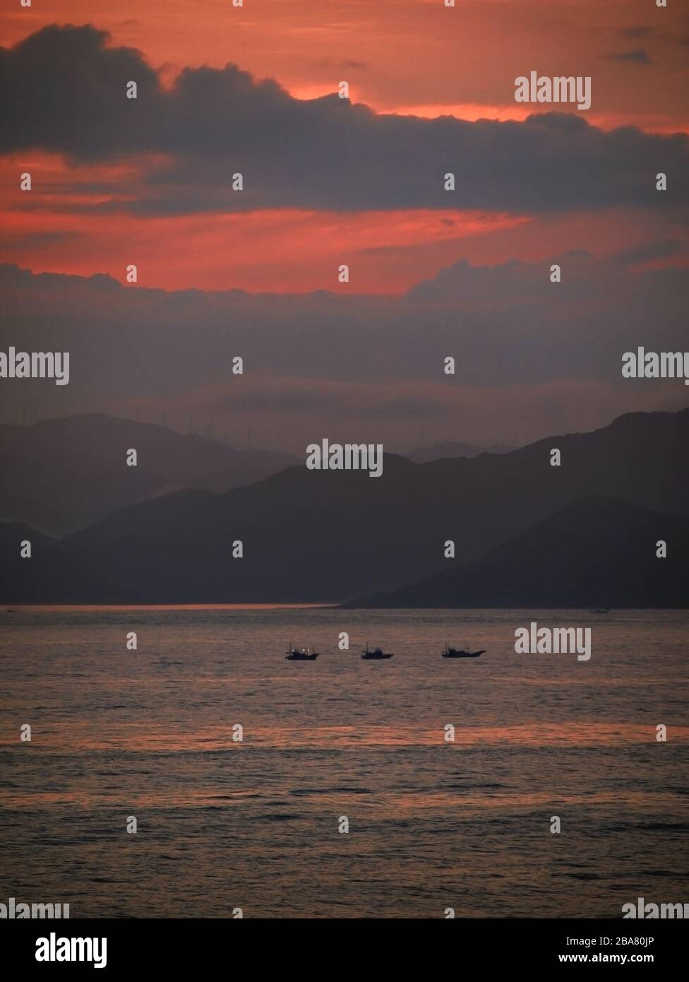 Distant view of a fishing boat fishing in the sea off the coast of Kii Peninsula where the sunrise glows Stock Photo