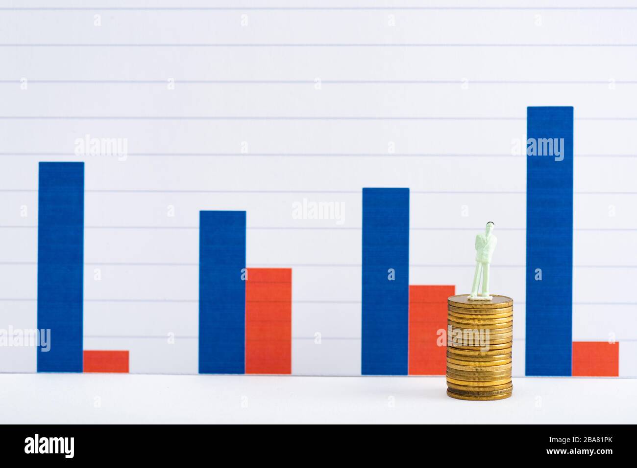 People figure on golden coins on white surface with blue and red graphs at background, concept of financial equality Stock Photo