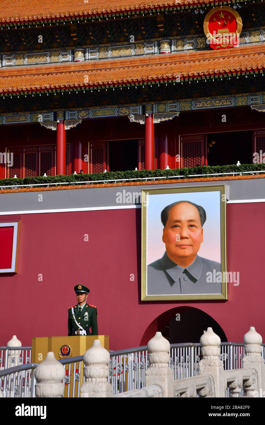 Beijing, China - October 2019; Close up of guard in front of Tiananmen gate entrance to Forbidden city with a portrait of President Mao Zedong hanging Stock Photo